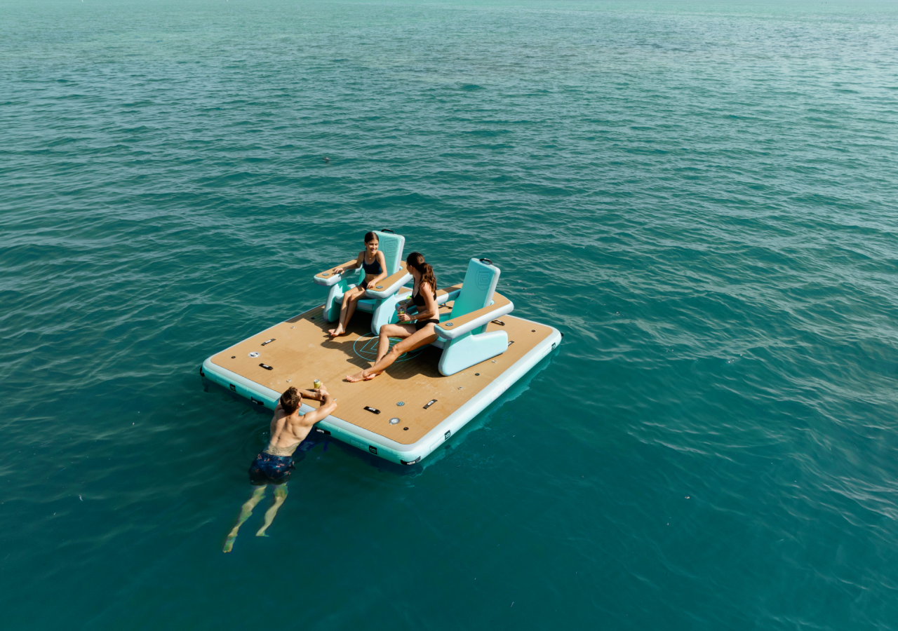 Three people relaxing on a floating dock