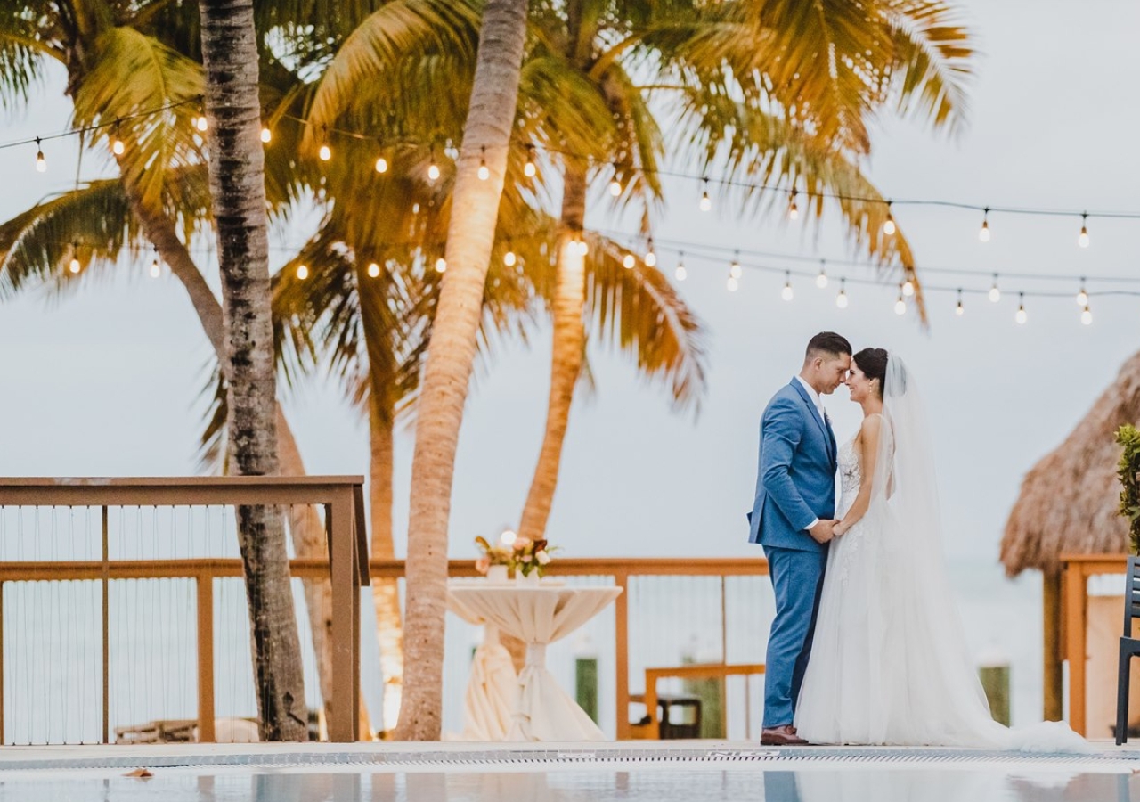 bride and groom standing on the edge of the book deck holding hands