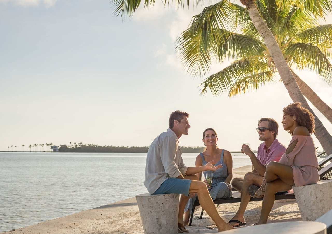 group on adults sitting on chairs on the beach