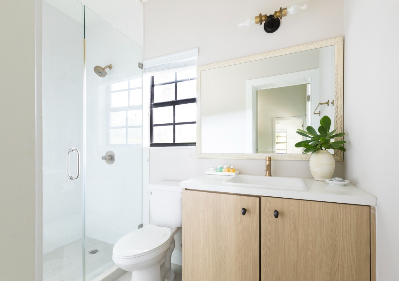 shower and sink in a brightly lit bathroom in a hotel room