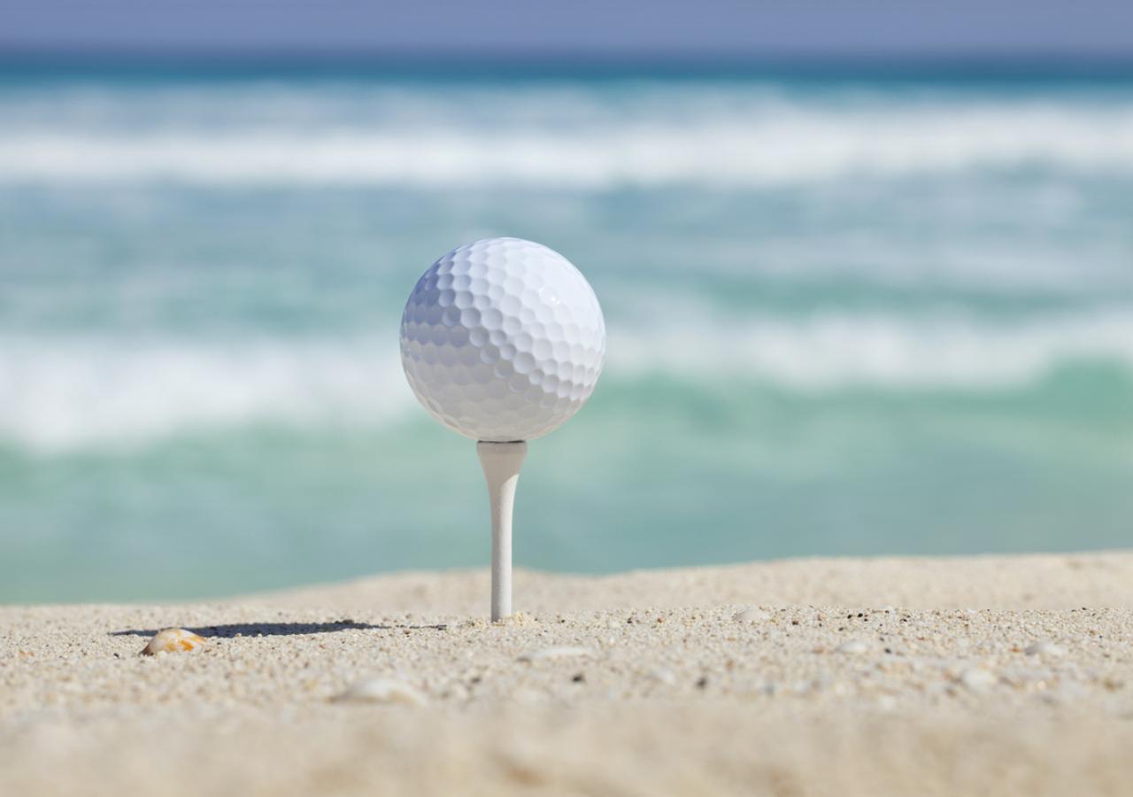 Golf ball on tee in the sand